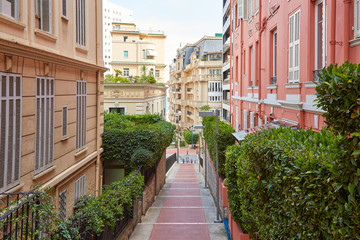 Fototapeta na wymiar Narrow pedestrian alley in Monte Carlo with luxury buildings, summer day in Monaco