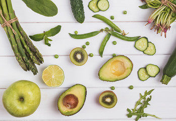 Creative composition with different green colored vegetables and fruits on the white background