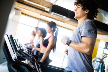 Fototapeta na wymiar Fit people running in machine treadmill at fitness gym