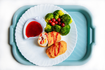Tasty chicken nuggets  on a white plate with sauce. Dish for dinner on white  background. Top view, flat lay 