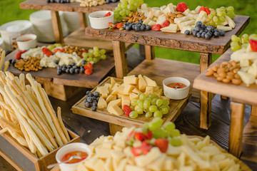 Food for a special celebration, slices of sliced cheese laid out with strawberries and lochins and various nuts