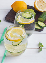Water infused with mint, lemon and cucucmber on the white wooden table
