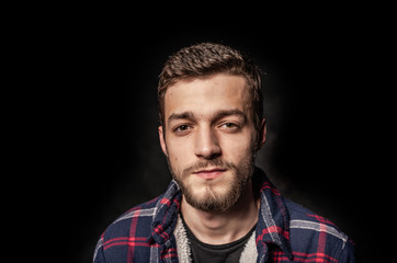 Bearded young man on a dark background.