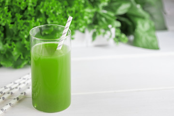 Freshly blended green smoothie in in a glass with straws on the table. Detox vegetable juice....