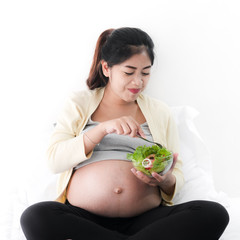 Asian pregnant woman eating fruit salad, lifestyle concept.