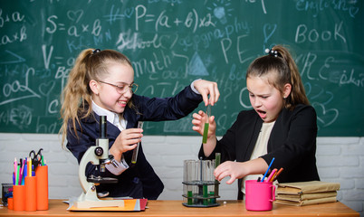 Microscope and test tubes on table. Educational experiment concept. Be careful performing chemical reaction. Basic knowledge of chemistry. Girls study chemistry. Make studying chemistry interesting