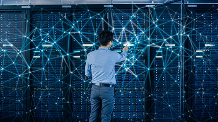 Internet Web Concept. Shot In the Modern Data Center: IT Engineer Standing Beside Open Server Rack...