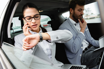 Young business people working together while traveling by a car.