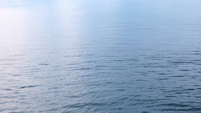Wind blowing over water making shallow blue ripples on surface of sea.