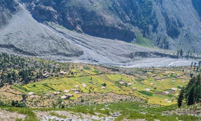 A village in the mountains with high mountain in background