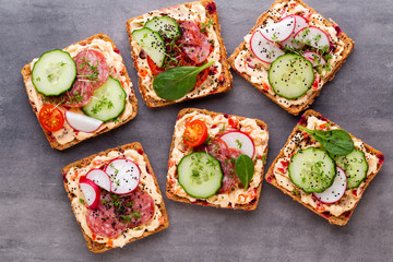 Sandwiches with cream cheese, vegetables and salami.