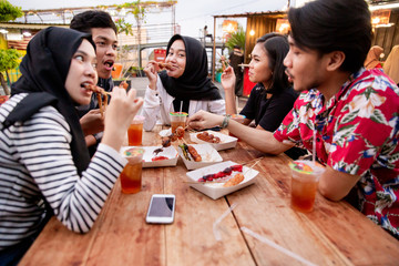 Young people lunch together when hanging out on the rooftop outdoor foodcourt
