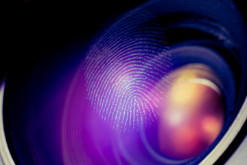 Fingerprint macro on a lens, red shadows. Biometric and security concept.