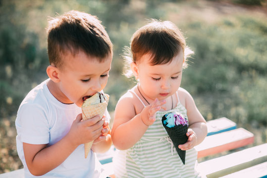 Children, Brother And Sister On The Bench Eating Ice Cream Is A Lot Of Fun