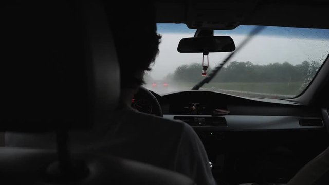 Man Driving A Car In The Rain In The Windshield Dripping Water