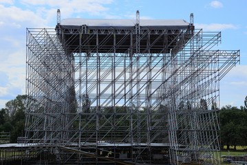 the frame of an unfinished metallic gray scene from twigs stands on green grass 