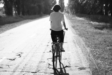 Happy girl rides a classic bike among beautiful nature.