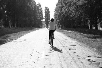Happy girl rides a classic bike among beautiful nature.
