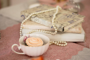 Vintage cup, pearls and books