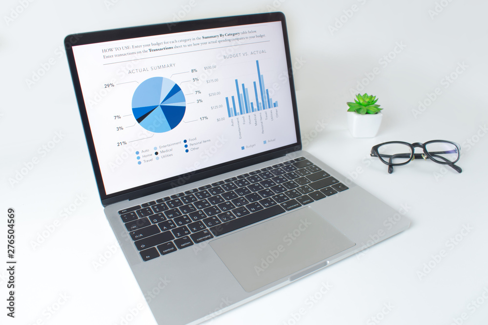 Fototapete modern white table with laptop computer with financial statistics report