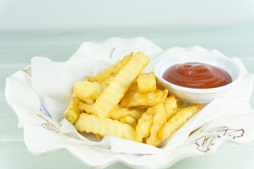 French Fries in a white dish on a table white background, Front view with copy space for your text.
