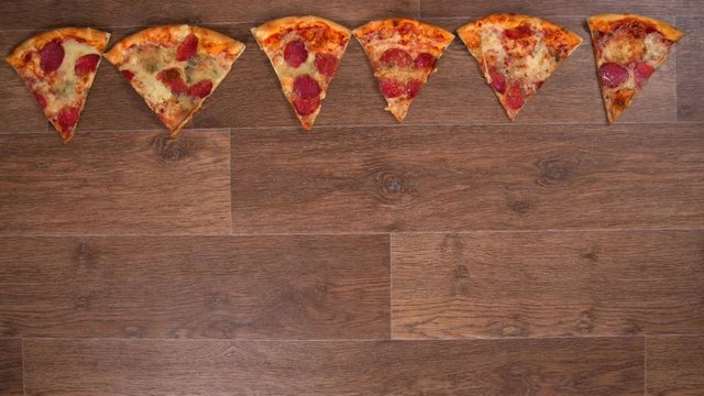 Pieces of pizza are separated and lined up, stop motion animation, 4K Video