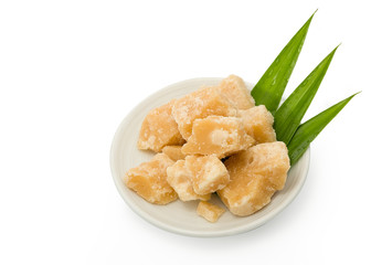 Coconut sugar in ceramic dish on a white background. Jaggery, Palm.