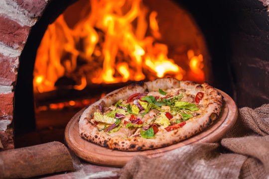 tasty pizza out of oven in restaurant kitchen