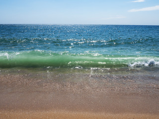 Waves on a sunny beach without objects and people. Copy space.
