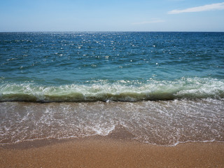 Waves on a sunny beach without objects and people. Copy space.