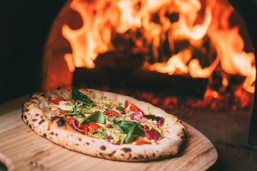 tasty pizza out of oven in restaurant kitchen