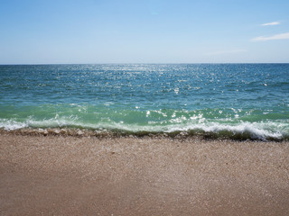Waves on a sunny beach without objects and people.