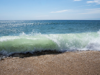 Waves on a sunny beach without objects and people. Copy space.