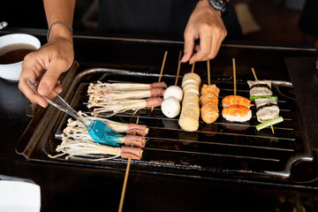 chef cooking korean food with skewers in hot pan