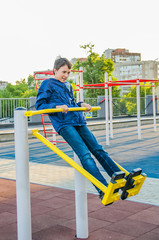 Fototapeta premium Teenager trains on the training apparatus