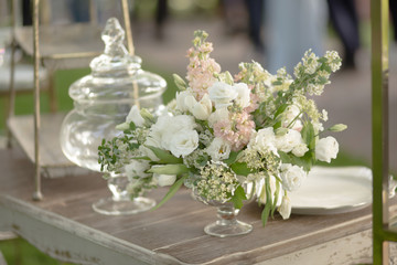 Bouquet decor in a glass vase on a wooden table for a wedding or birthday party