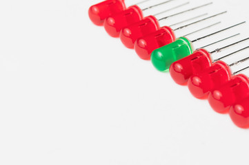 Be different and stand out from the crowd concept: one green LED between eight red ones. White...