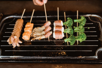human hands cook shaokao grilling food, smears it with a brush