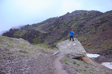 a young man in a blue jacket admires the views of the mountains