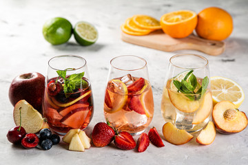 Selection of sangrias - red, pink, white and ingredients, rustic background