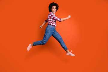 Full body side photo of excited jumping high model lady yelling loud rushing shopping wear casual clothes outfit isolated orange background