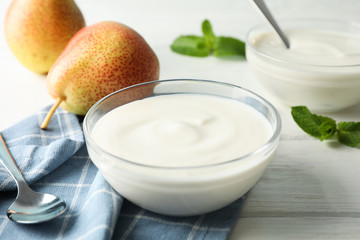 Composition with cream yogurts and fruits on white background, space for text
