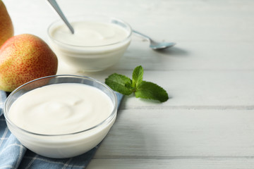 Composition with cream yogurts and fruits on white background, space for text
