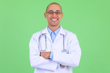 Happy bald multi ethnic man doctor smiling with arms crossed