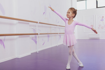 Full length shot of a cute young ballerina girl dancing at ballet school gracefully, copy space