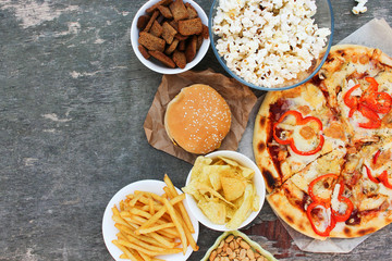 Fast food on old wooden background. Concept of junk eating. Top view. Flat lay.