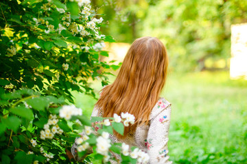 Fototapeta na wymiar portrait of a girl in bush of jasmine