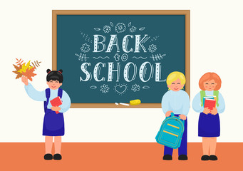 Back to school. Primary school students standing near blackboard 