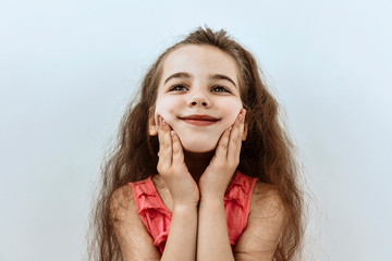 Dreamy,pleased, thinking emotion . Wish concept. Little girl face portrait on white backgound.