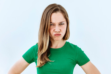 Fototapeta premium Annoyed and upset emotion. Headshot portrait of young girl against white background